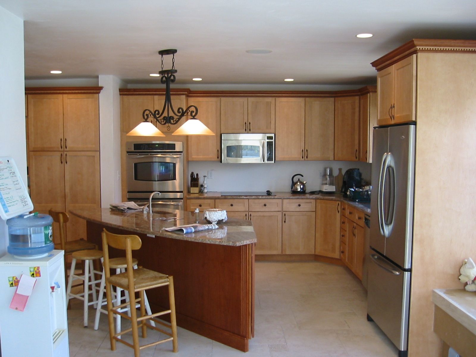 Kitchen with light wood cabinets, granite countertops, and stainless steel appliances.