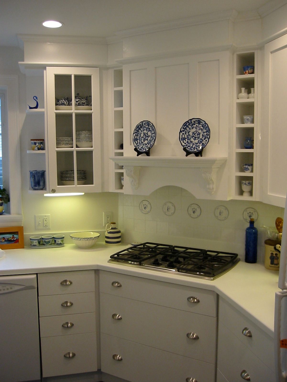 White kitchen cabinets with blue and white dishware displayed.