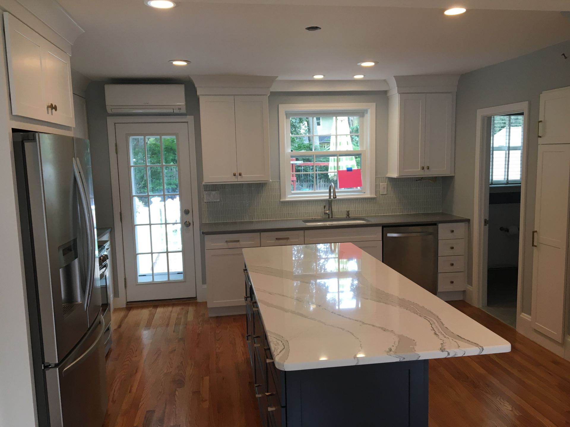 Modern kitchen with white cabinets, gray countertop, and island with patterned quartz.