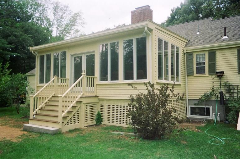 Yellow house with a screened-in porch, stairs leading down to the grass.