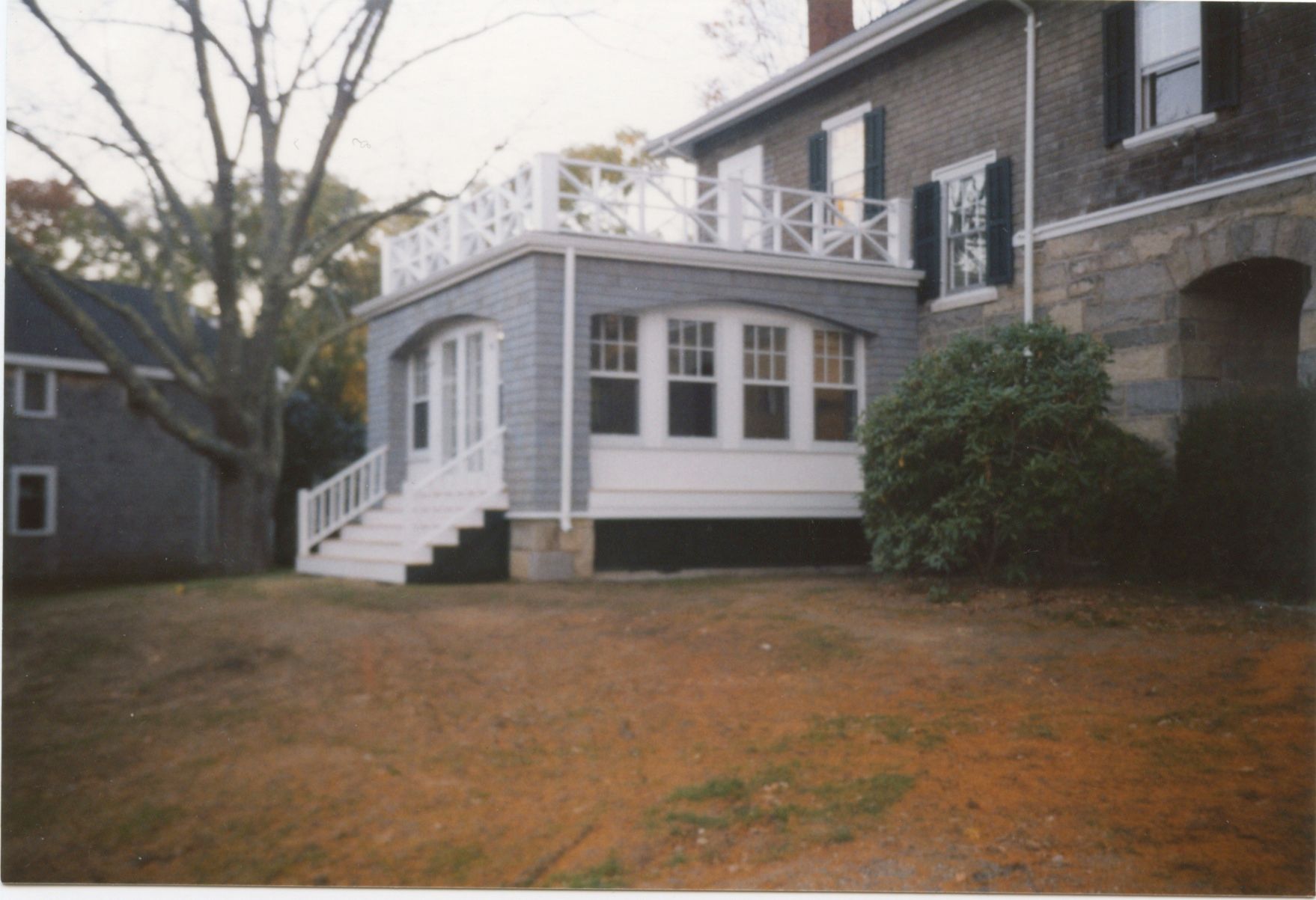 House exterior with a porch and rooftop deck. The yard is grassy.