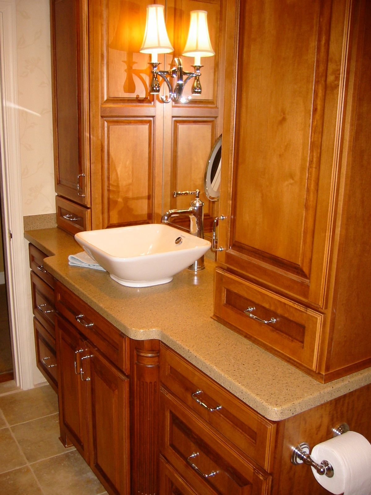 Bathroom with wood cabinets, a vessel sink, and a beige countertop.