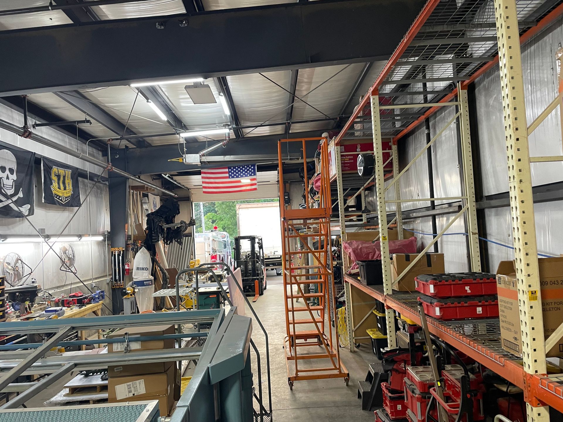 Warehouse interior with shelving, lift, and an American flag.