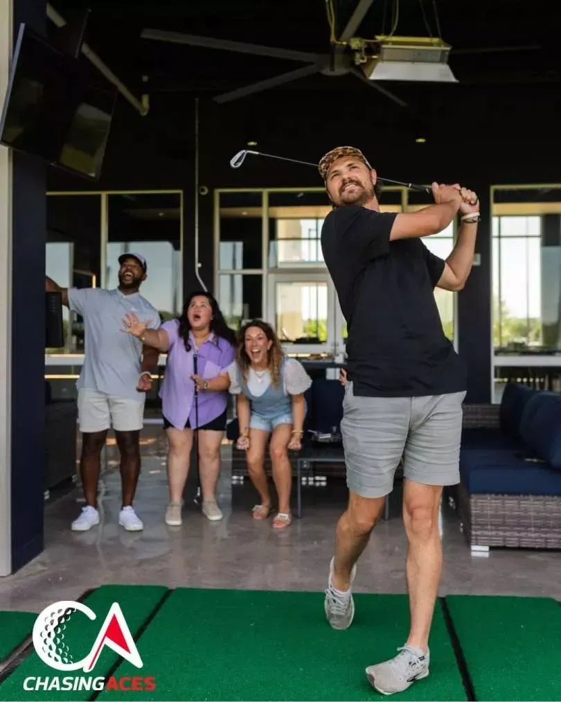 A group of people are watching a man swing a golf club