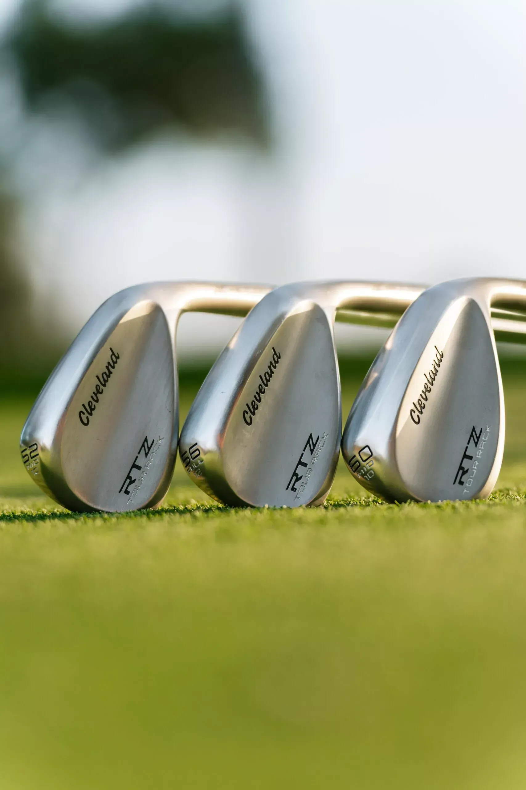Three wedges are sitting on top of a golf course.