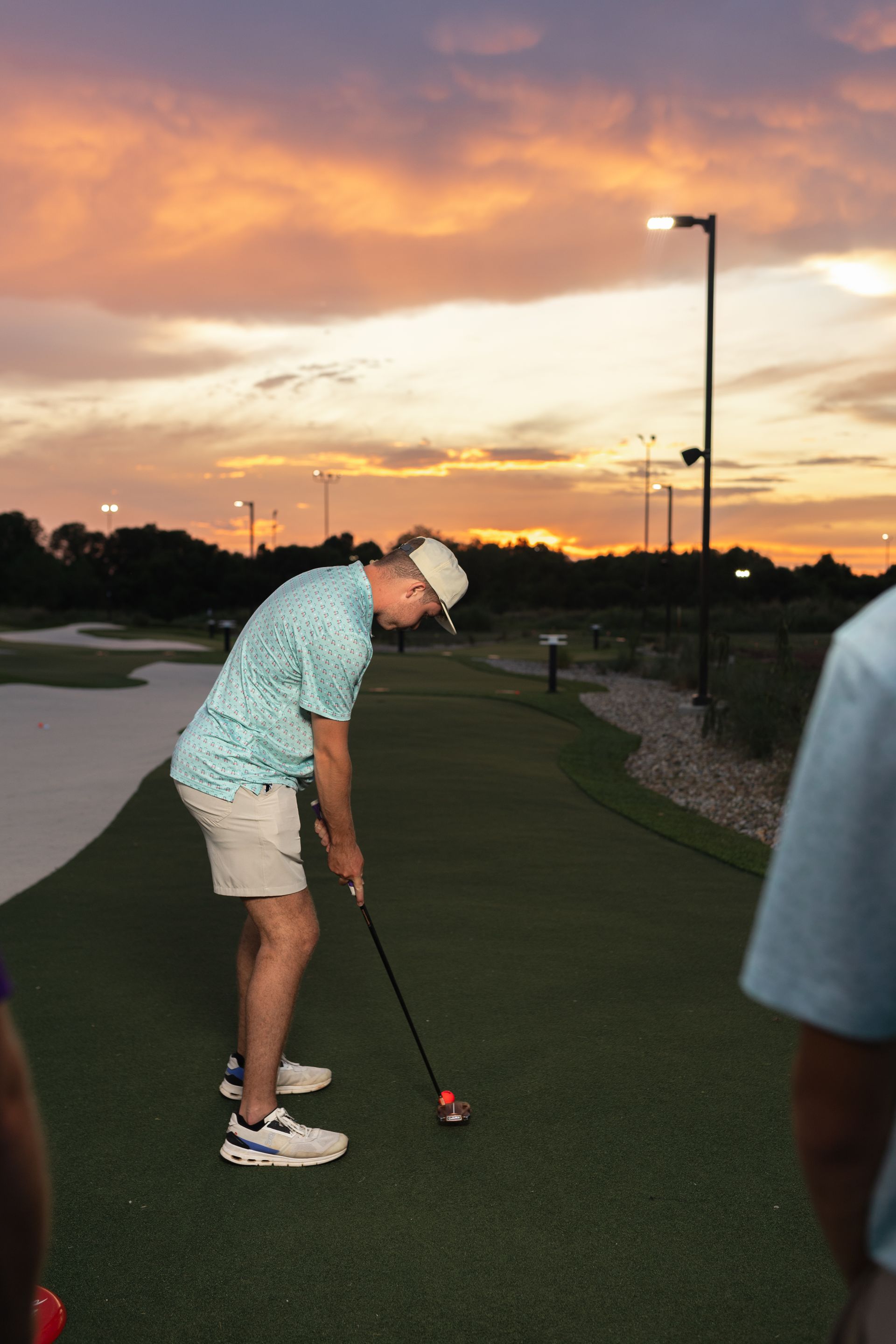 A man is jumping in the air while holding a golf club on a golf course.