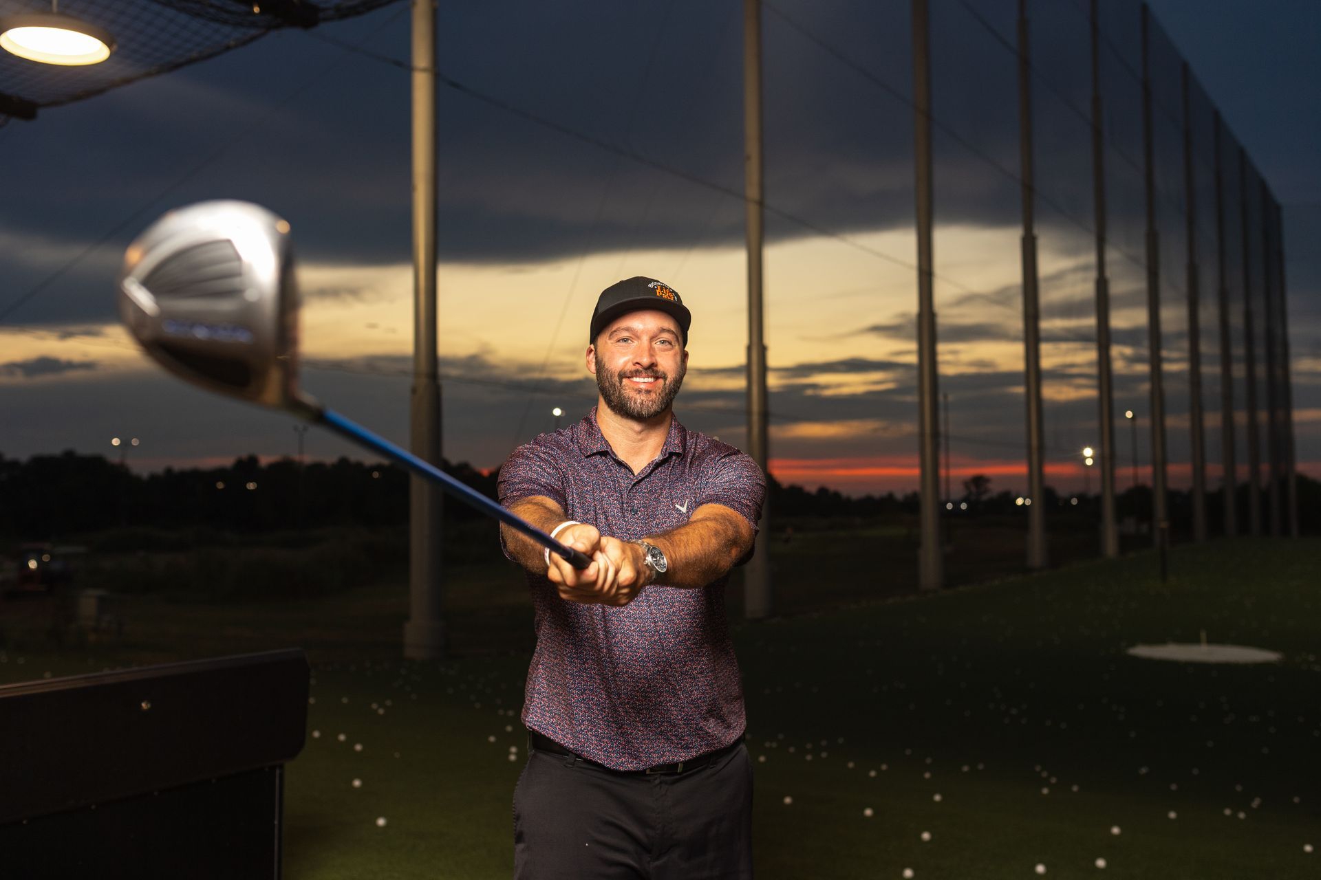 Golfer swinging a club at dusk