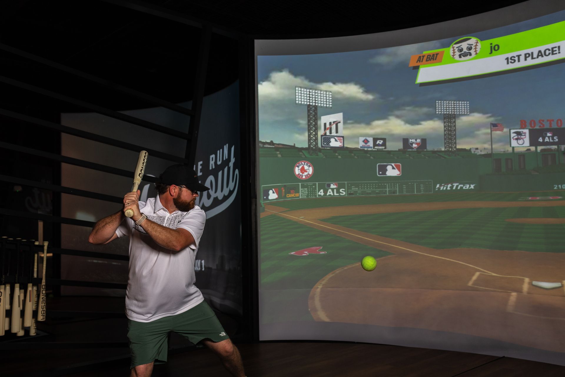 A woman is swinging a bat at a ball in a virtual baseball game.