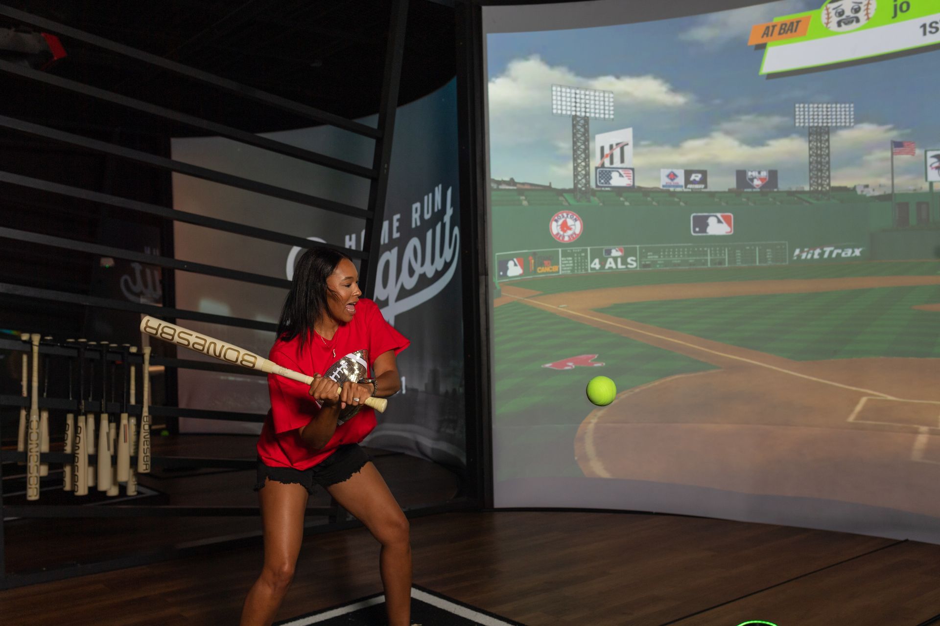 A man is playing a video game on a baseball field.