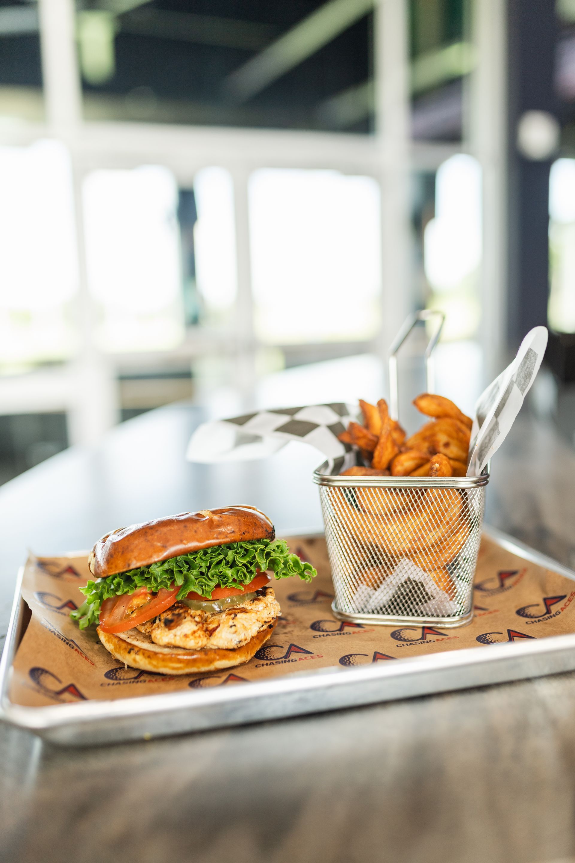A hamburger and french fries are on a tray on a table.