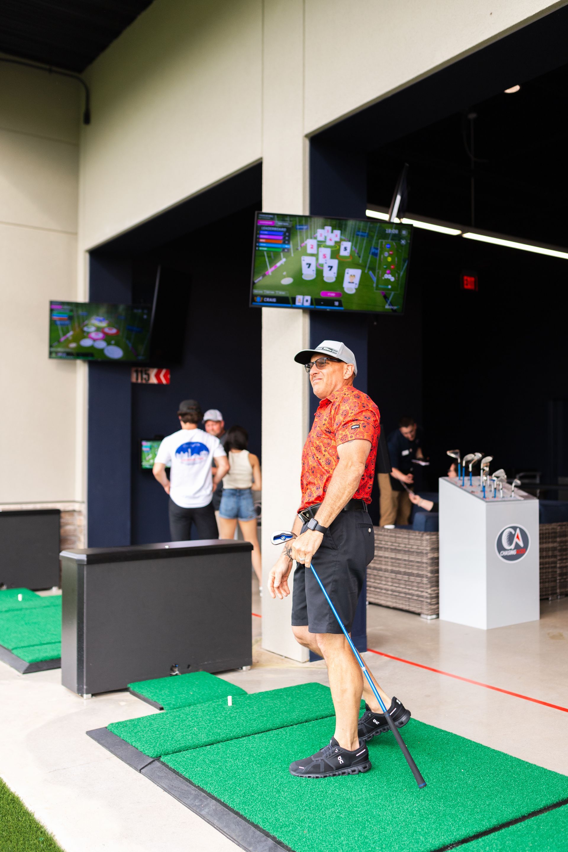 A man is standing on a golf course holding a golf club.