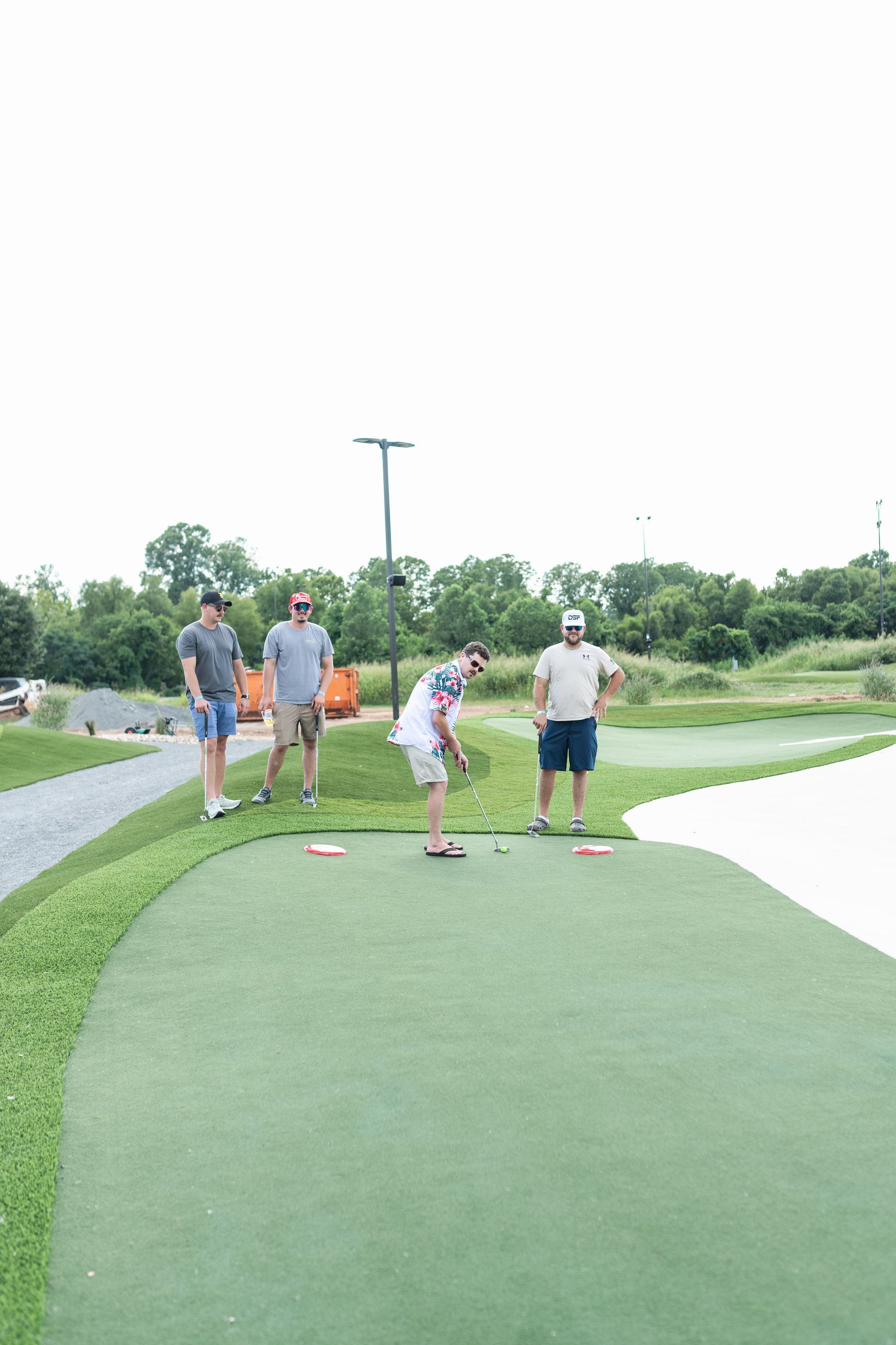 A group of people are playing a game of golf on a green.