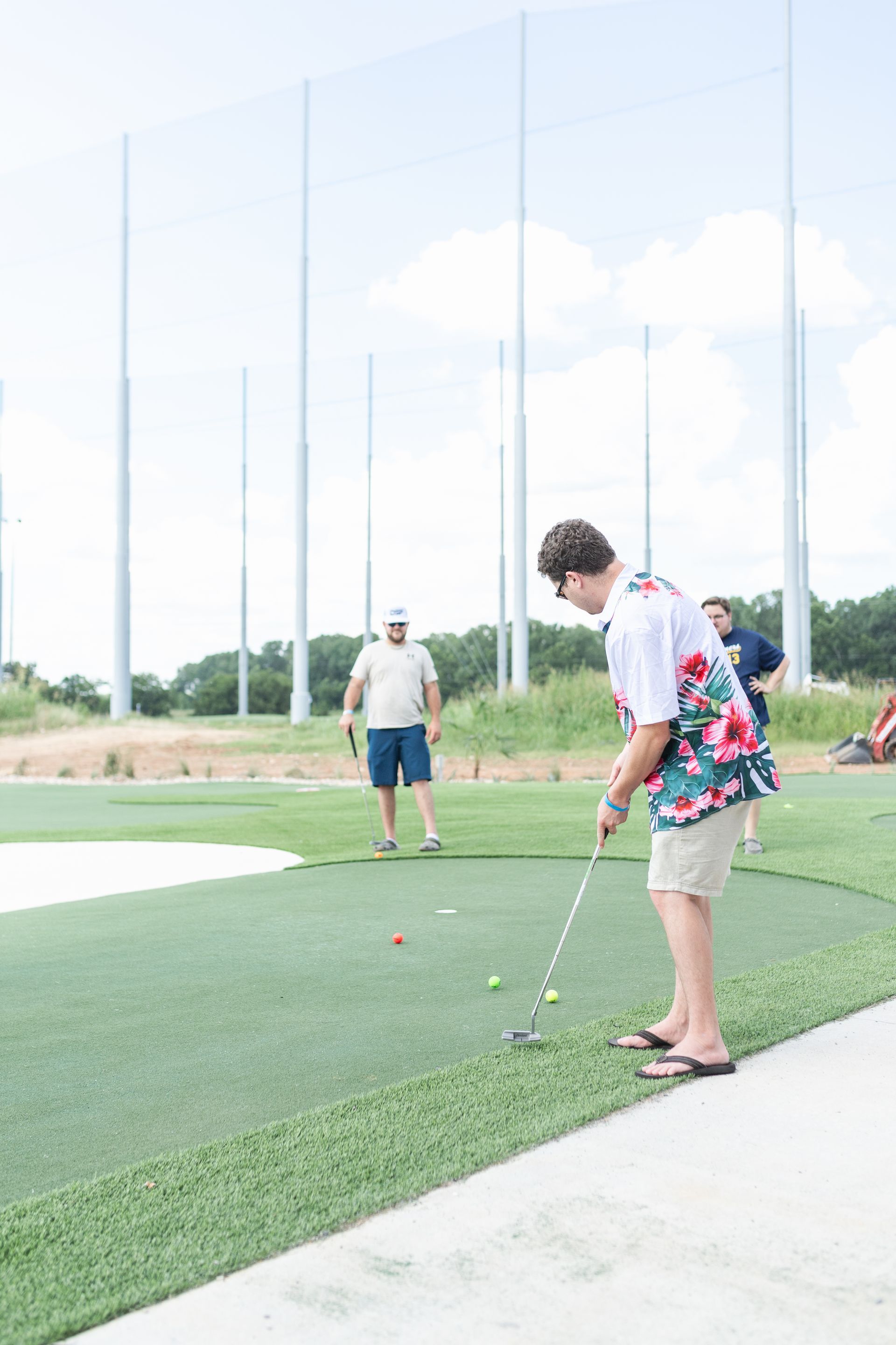 A man is putting a golf ball on a golf course.