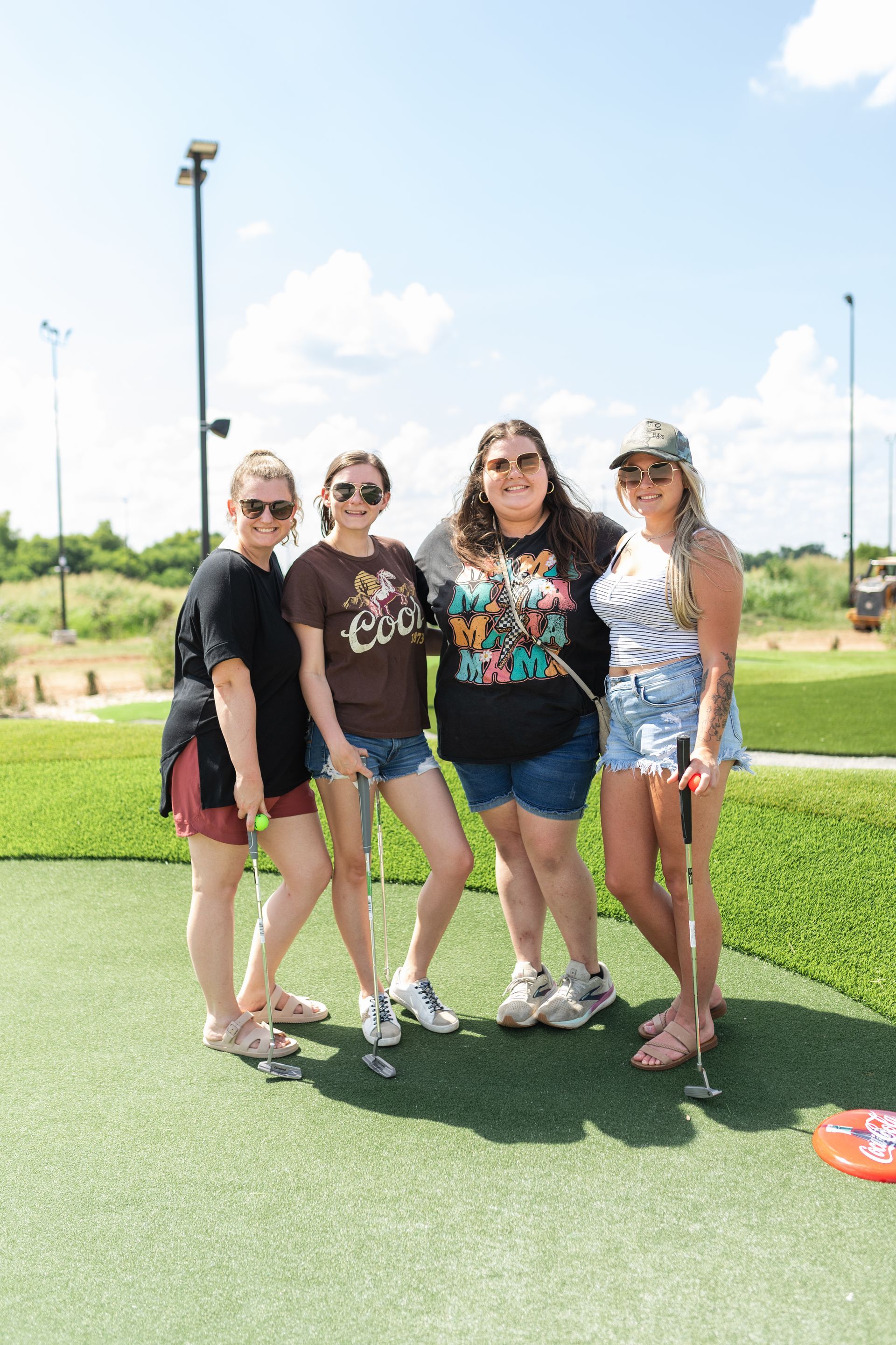 A group of women are posing for a picture on a golf course.