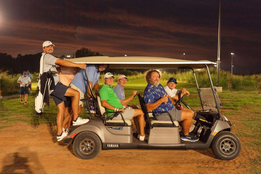 A group of people are sitting on a couch watching a game.