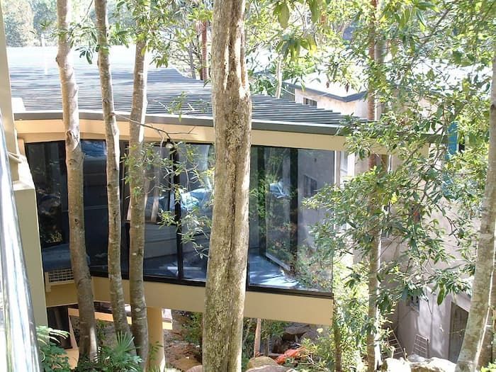 A House With A Lot Of Windows Is Surrounded By Trees — South Coast Glass In South Nowra, NSW