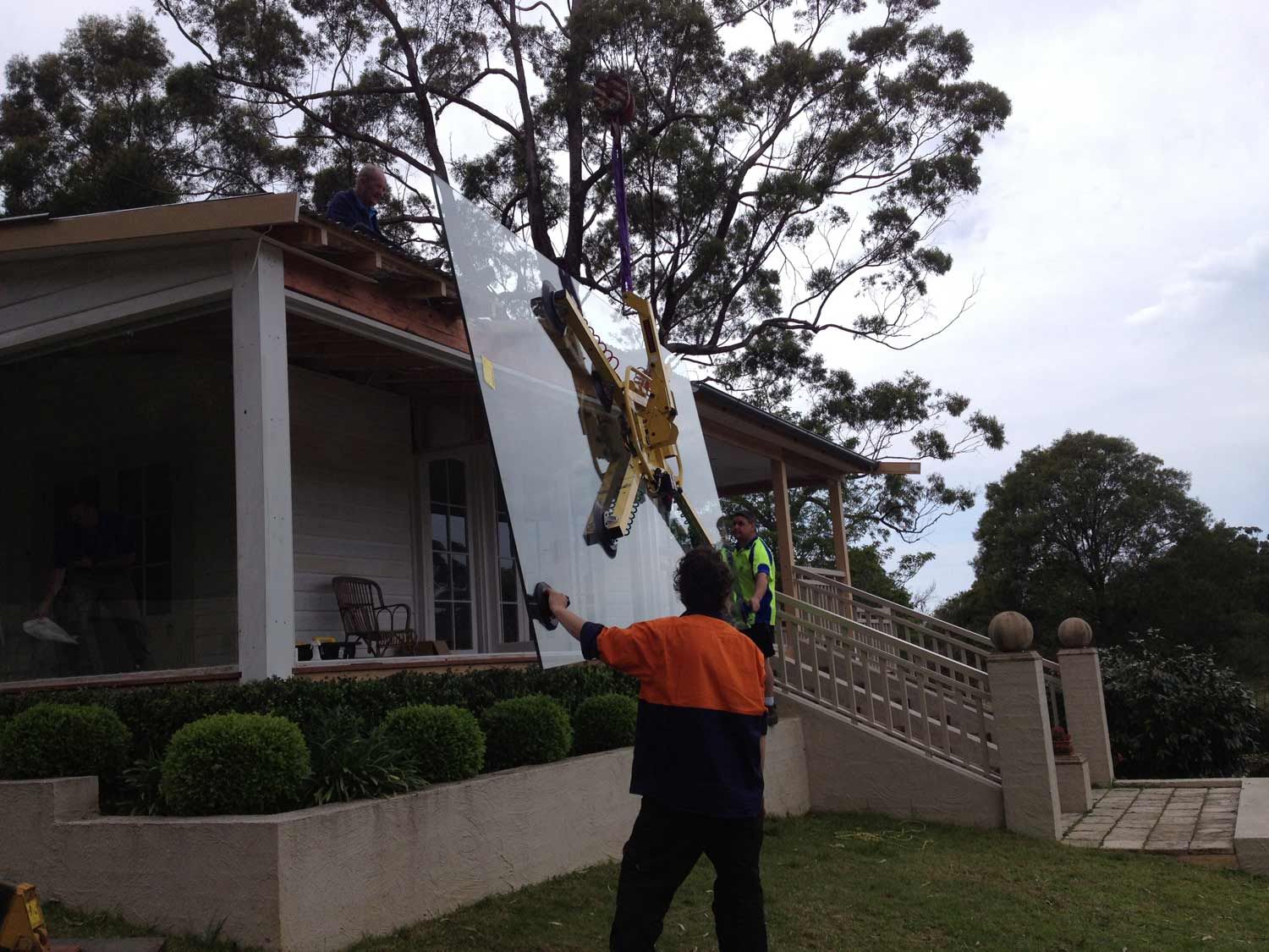 A Crane is Holding Large Piece of Glass for Window — South Coast Glass In South Nowra, NSW
