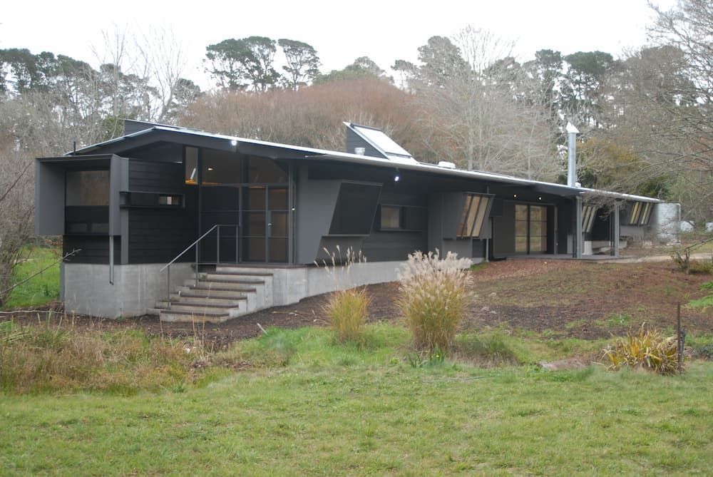 A Large Black House Is Sitting In The Middle Of A Grassy Field — South Coast Glass In South Nowra, NSW
