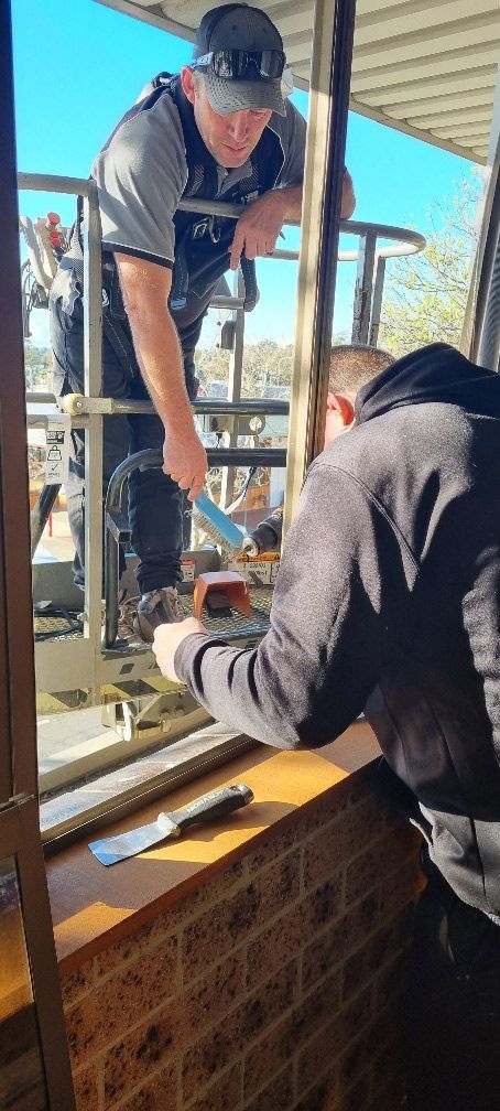Workers Manually Installing Glass — South Coast Glass In South Nowra, NSW