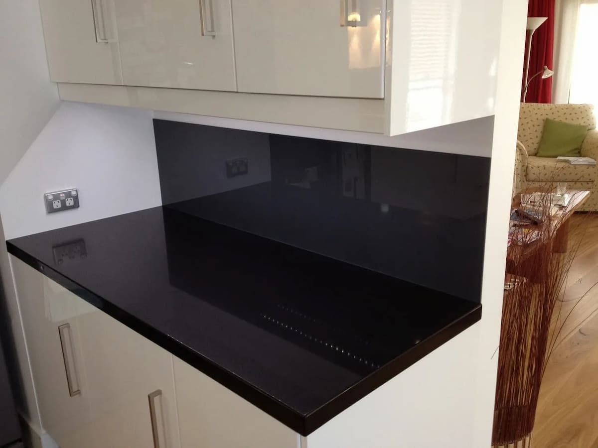 A Kitchen With A Black Counter Top And White Cabinets — South Coast Glass In South Nowra, NSW