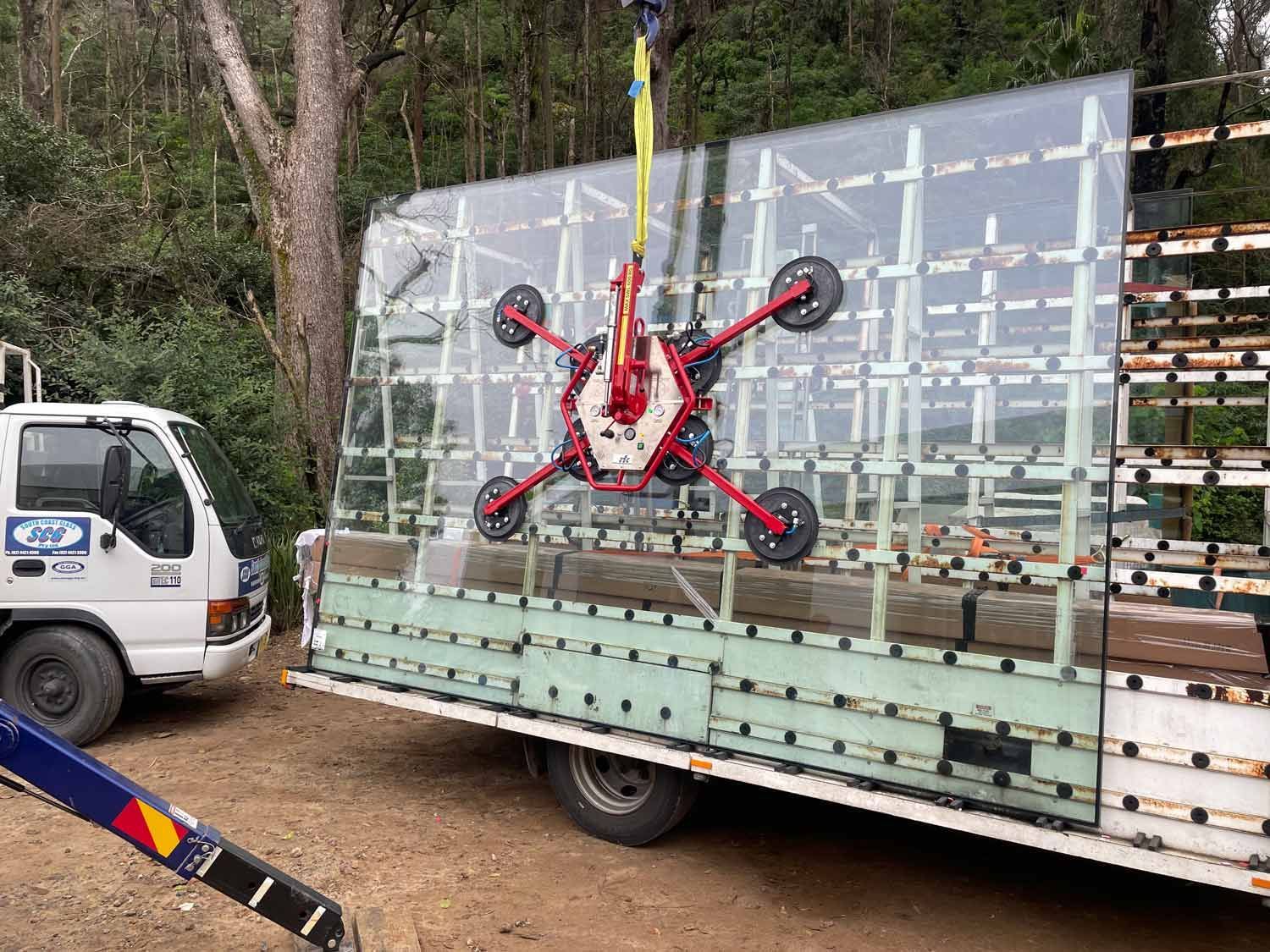 A Crane Holding Large Piece Glass — South Coast Glass In South Nowra, NSW