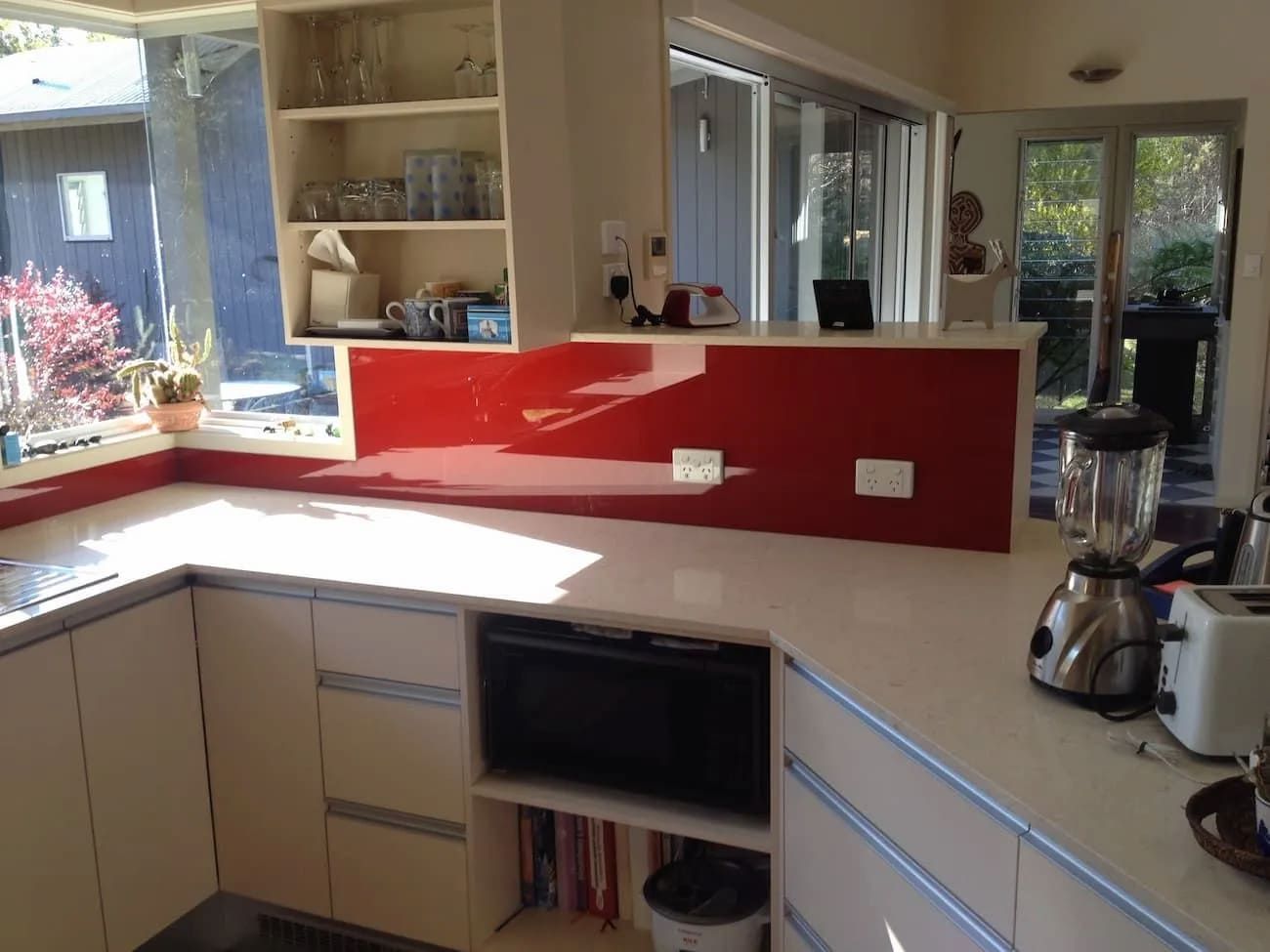 A Kitchen With White Cabinets And A Red Backsplash — South Coast Glass In South Nowra, NSW