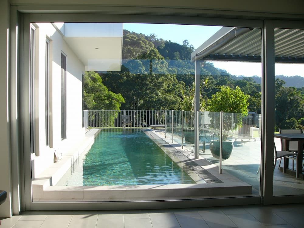 A View Of A Swimming Pool Through A Sliding Glass Door — South Coast Glass In South Nowra, NSW