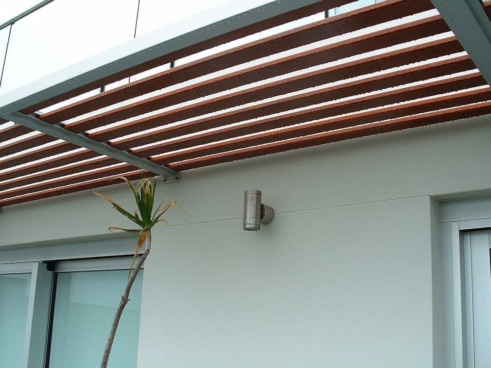 A White Building With A Wooden Roof And A Plant In Front Of It — South Coast Glass In South Nowra, NSW