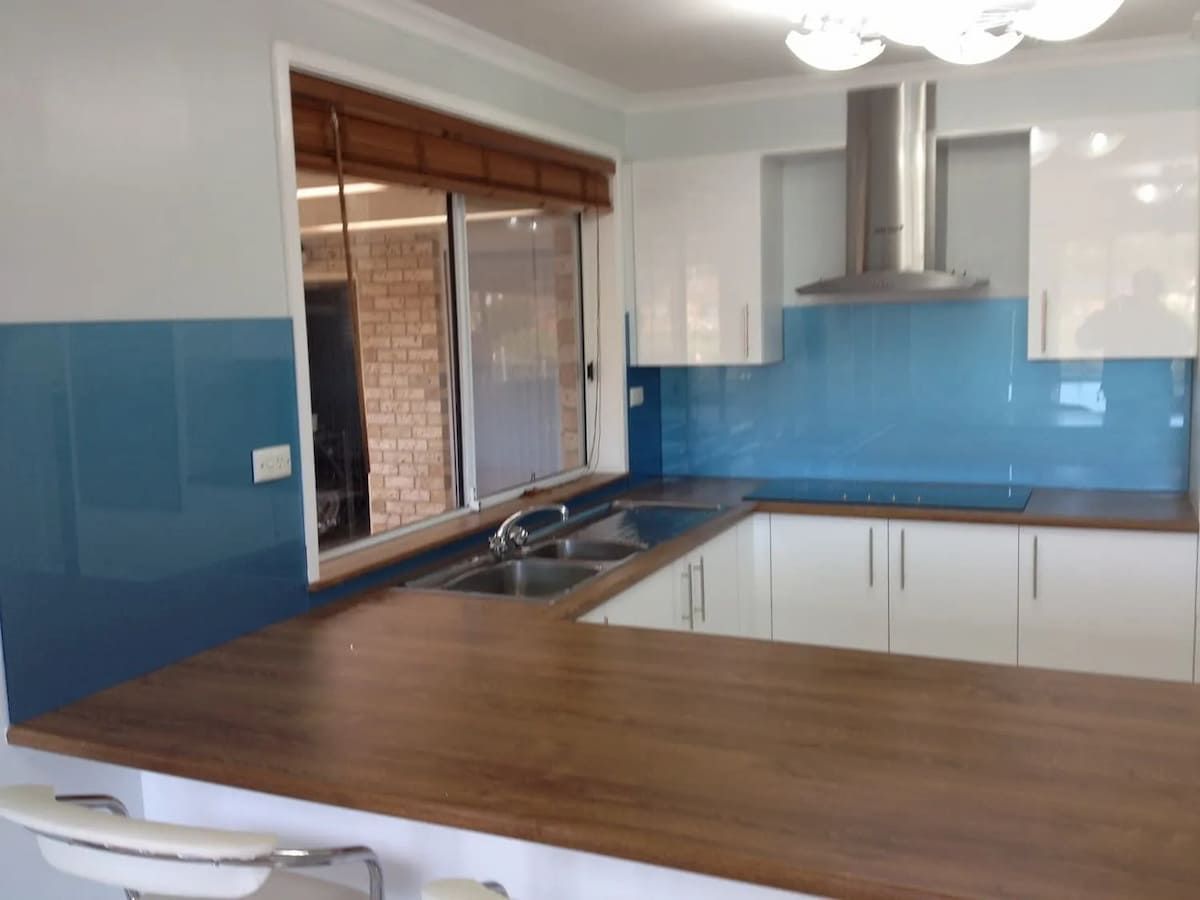 A Kitchen With Blue Walls And White Cabinets — South Coast Glass In South Nowra, NSW