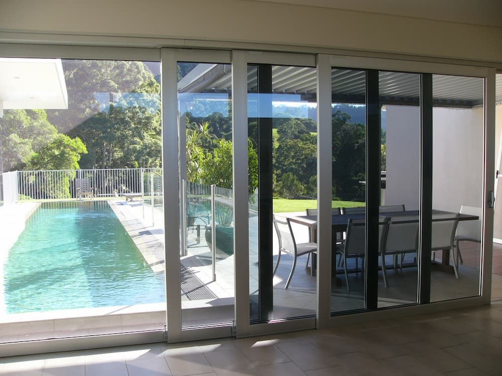 A Swimming Pool Is Visible Through The Sliding Glass Doors — South Coast Glass In South Nowra, NSW