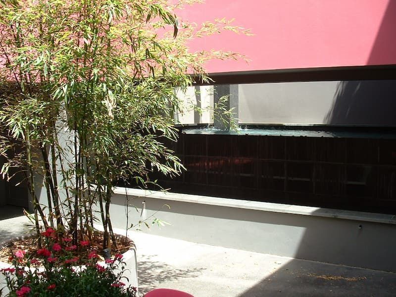 A Planter With Flowers In Front Of A Building With A Red Awning — South Coast Glass In South Nowra, NSW