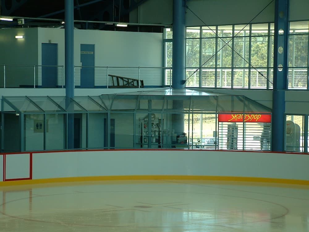An Empty Ice Rink With A Mcdonald's Sign In The Background — South Coast Glass In South Nowra, NSW