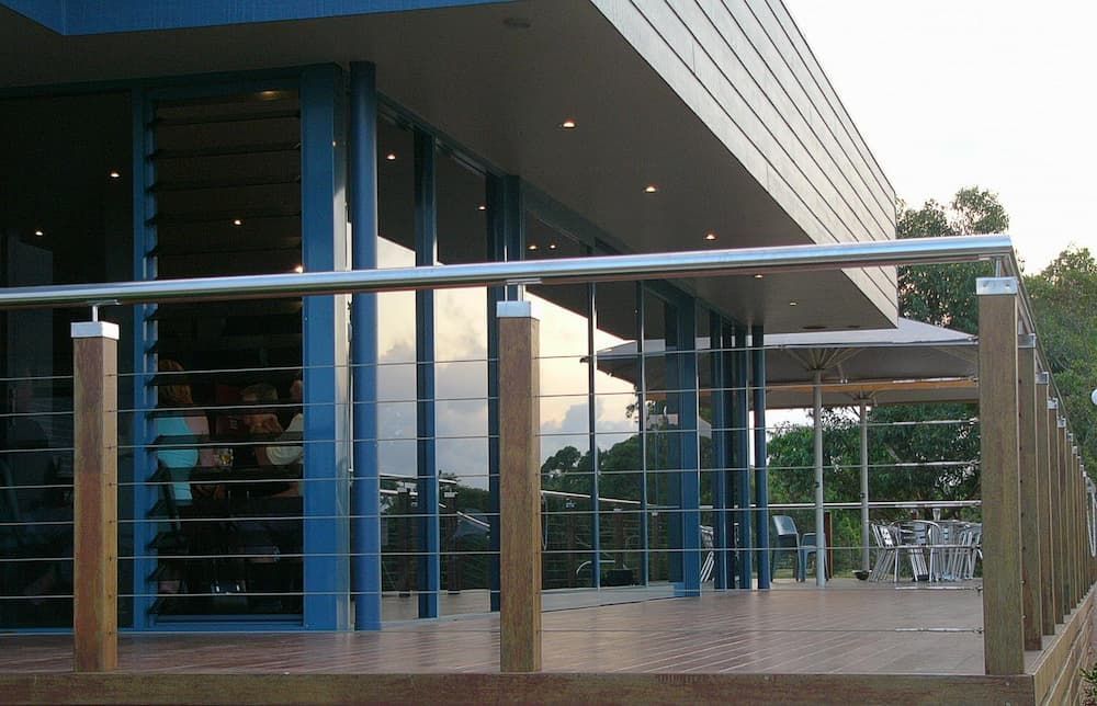 A Balcony With A Stainless Steel Railing In Front Of A Building — South Coast Glass In South Nowra, NSW