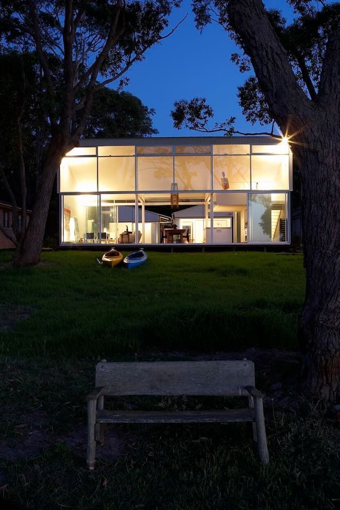 A Bench Sits In Front Of A House That Is Lit Up At Night — South Coast Glass In South Nowra, NSW