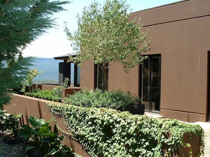 A Brown Building With Lots Of Windows And Trees In Front Of It — South Coast Glass In South Nowra, NSW