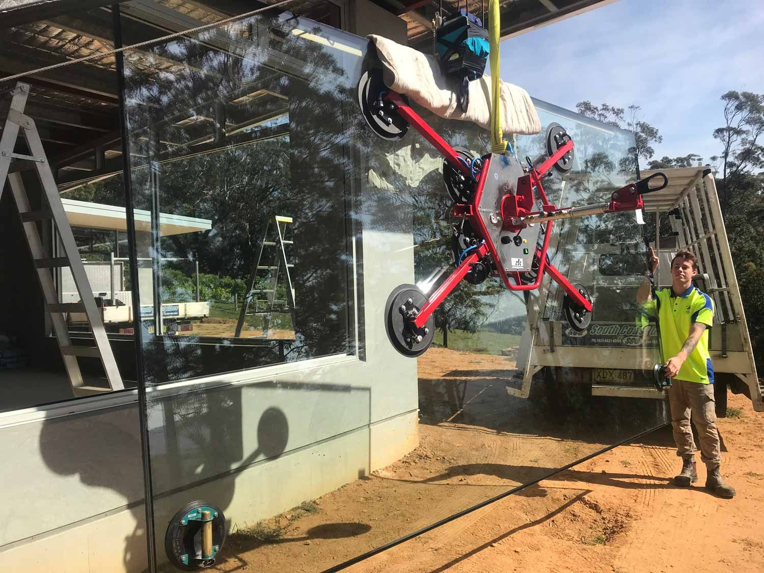 A Red Crane Installing Glass Wall — South Coast Glass In South Nowra, NSW