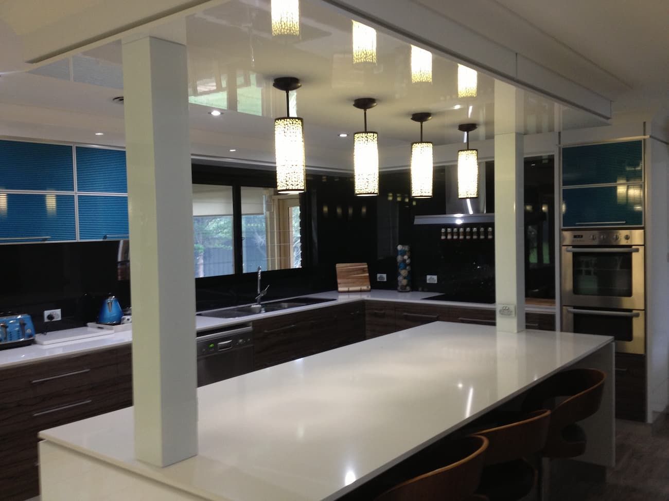 A Kitchen With Blue Cabinets And A White Counter Top — South Coast Glass In South Nowra, NSW