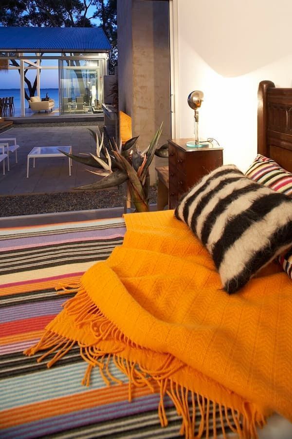 A Bed With An Orange Blanket And Black And White Pillows — South Coast Glass In South Nowra, NSW