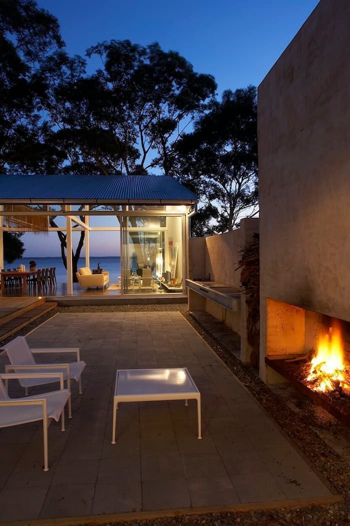 A Patio With A Fireplace And Chairs At Night — South Coast Glass In South Nowra, NSW
