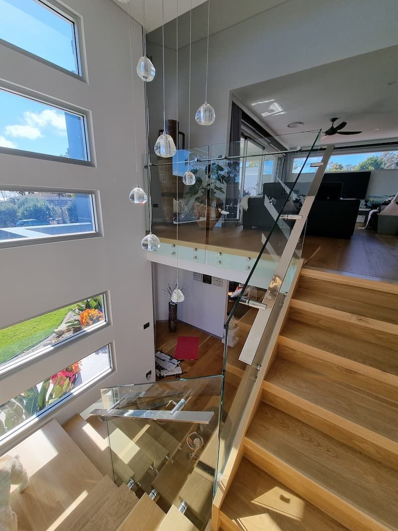 A Staircase In A House With A Glass Railing And Lots Of Windows — South Coast Glass In South Nowra, NSW