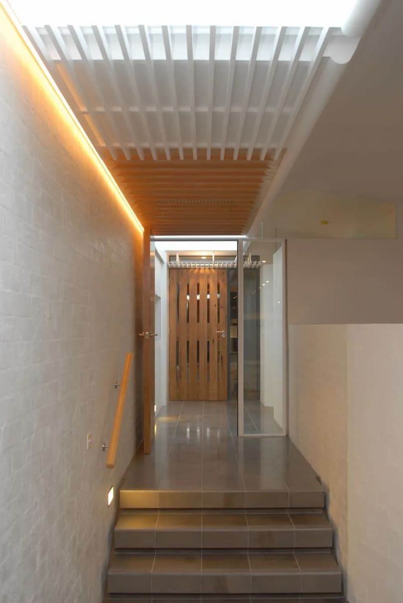 A Hallway With Stairs And A Wooden Door — South Coast Glass In South Nowra, NSW