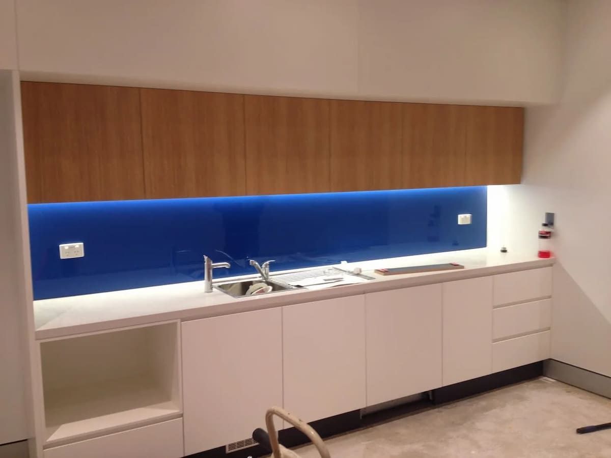 A Kitchen With White Cabinets And A Blue Backsplash — South Coast Glass In South Nowra, NSW