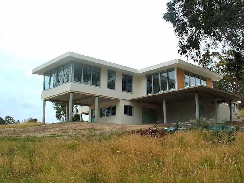 A Large White House With A Lot Of Windows Is Sitting On Top Of A Grassy Hill — South Coast Glass In South Nowra, NSW