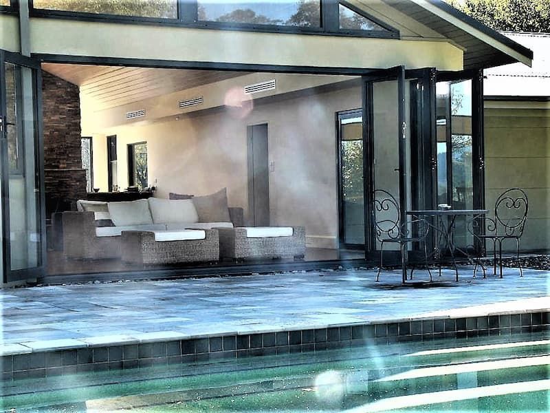 A House With A Patio And A Swimming Pool In Front Of It — South Coast Glass In South Nowra, NSW