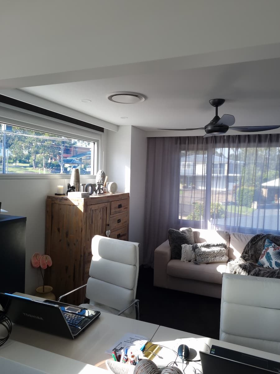 A Living Room With A Couch And A Desk With A Laptop On It — South Coast Glass In South Nowra, NSW
