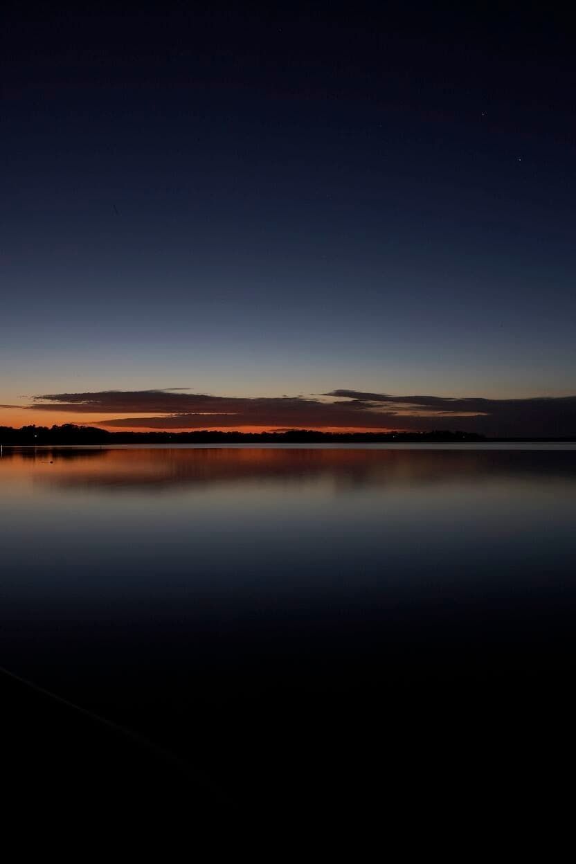 A Sunset Over A Body Of Water With A Dark Sky — South Coast Glass In South Nowra, NSW