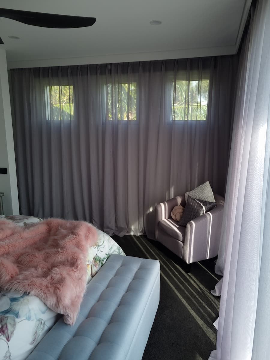 A Bedroom With A Bed A Chair And A Ceiling Fan — South Coast Glass In South Nowra, NSW