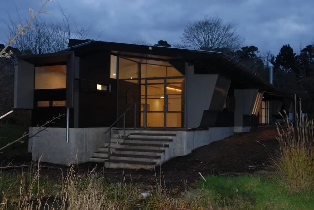 A House With Stairs Leading Up To It Is Lit Up At Night — South Coast Glass In South Nowra, NSW