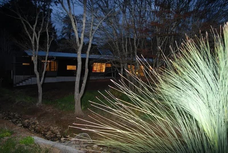 A House Is Lit Up At Night With Trees In The Background — South Coast Glass In South Nowra, NSW