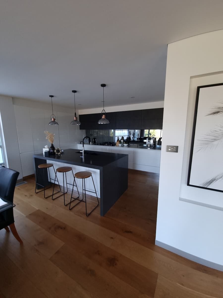 A Kitchen With Stools And A Picture On The Wall — South Coast Glass In South Nowra, NSW
